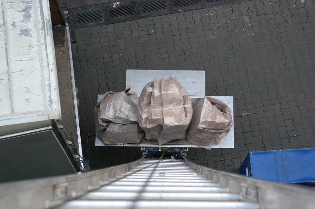 Asansör platformunda yukarı çıkan paketlenmiş eşyalar