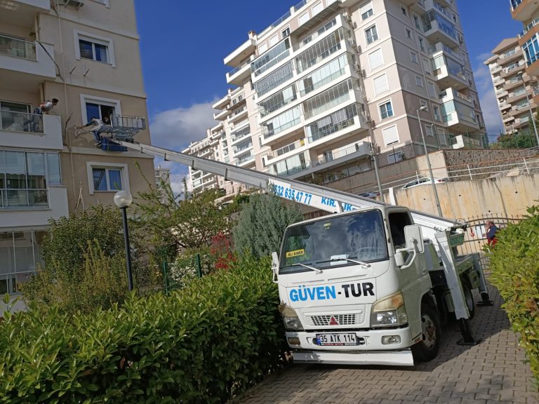 Güven-Tur asansör aracı site bahçesinde, apartman cephesine kurulmuş
