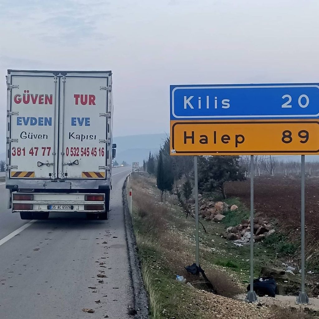 Güven-Tur kamyonu Kilis ve Halep yön tabelasının önünde
