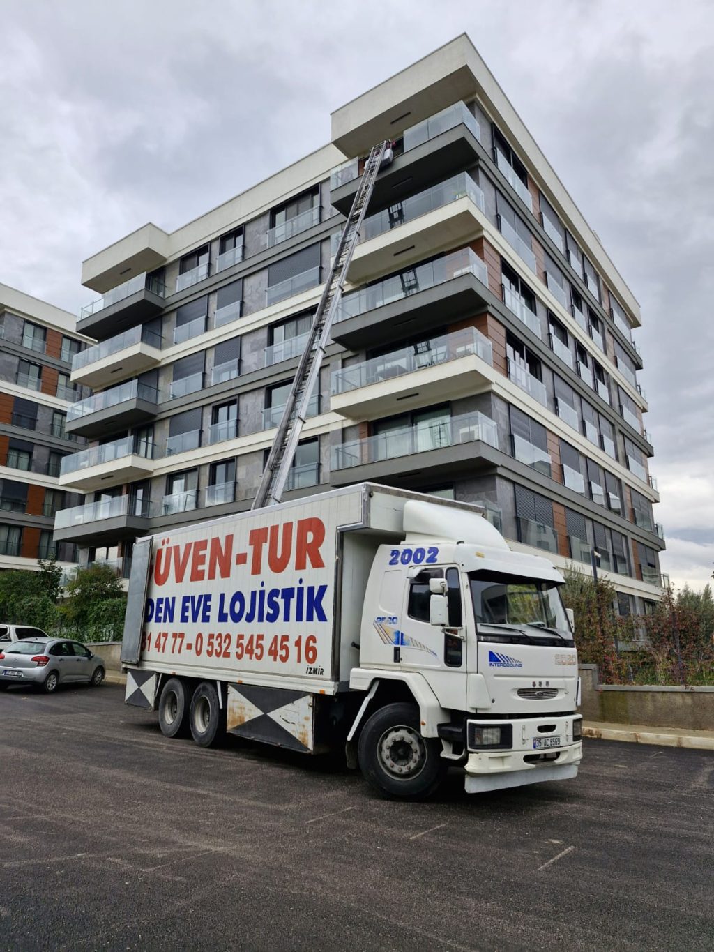 Güven-Tur kamyonu ve apartman cephesine uzanan asansörlü taşıma merdiveni