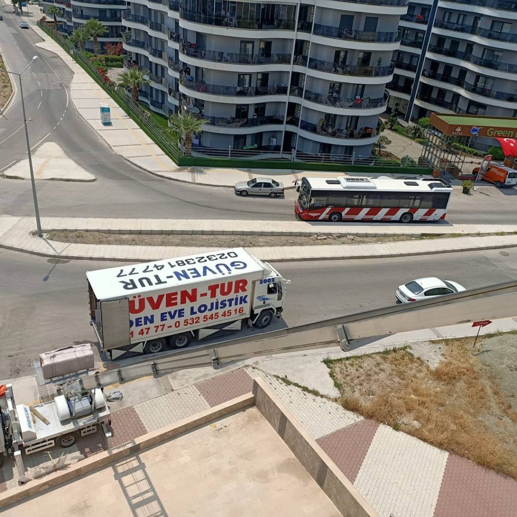 Yukarıdan görünüm: site yolunda bekleyen Güven-Tur kamyonu ve kurulu eşya asansörü
